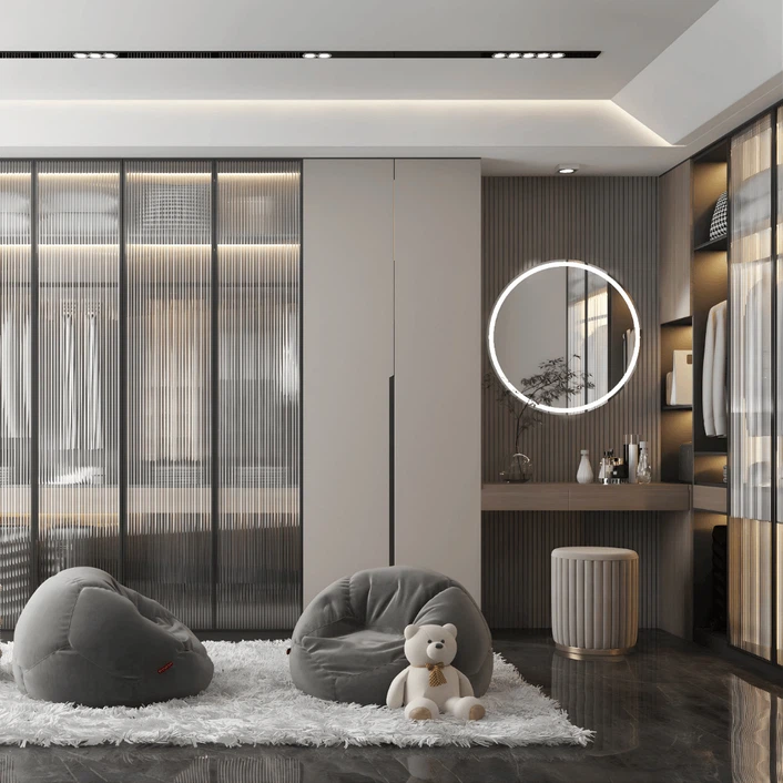 Modern wardrobe with glass sliding doors and dressing table area featuring round LED mirror. Modern wardrobe with glass sliding doors and dressing table area featuring round LED mirror.