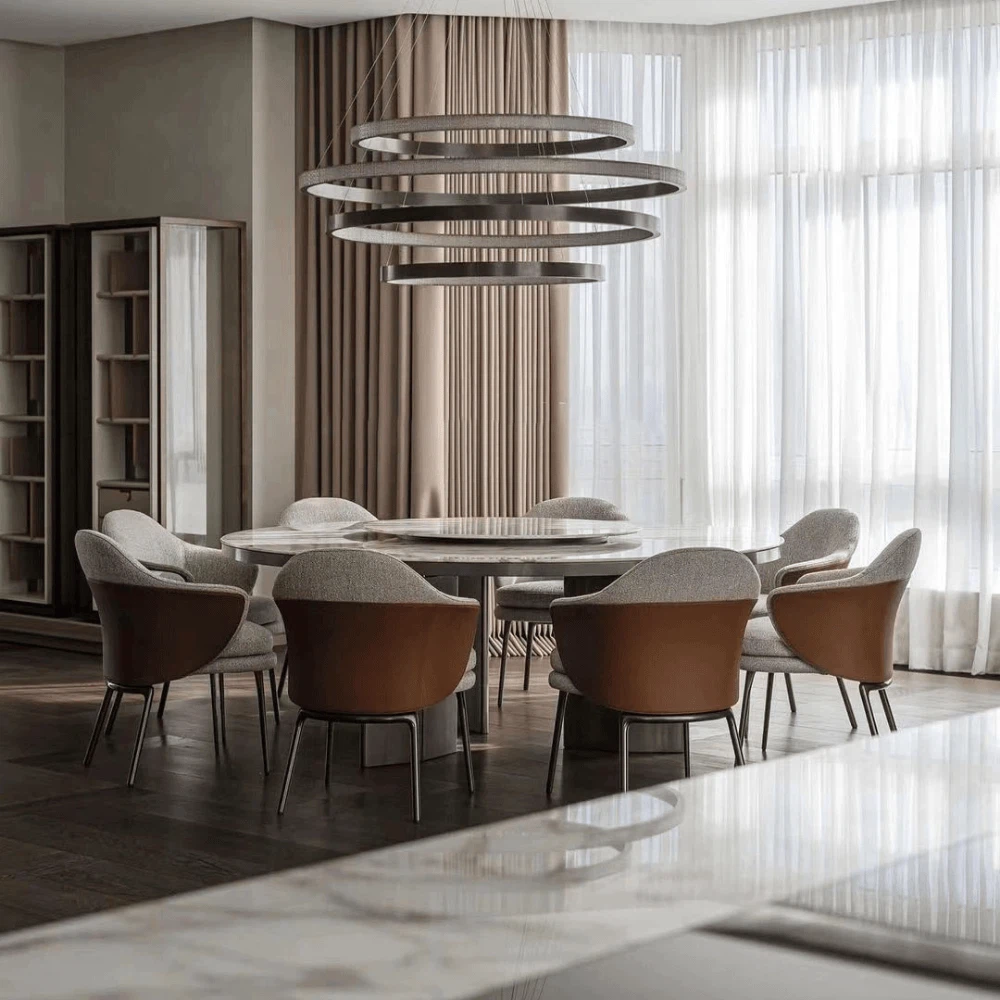 Modern dining room with Marble Top Round Dining Table Set placed near floor-to-ceiling windows and soft beige curtains. Modern dining room with Marble Top Round Dining Table Set placed near floor-to-ceiling windows and soft beige curtains.